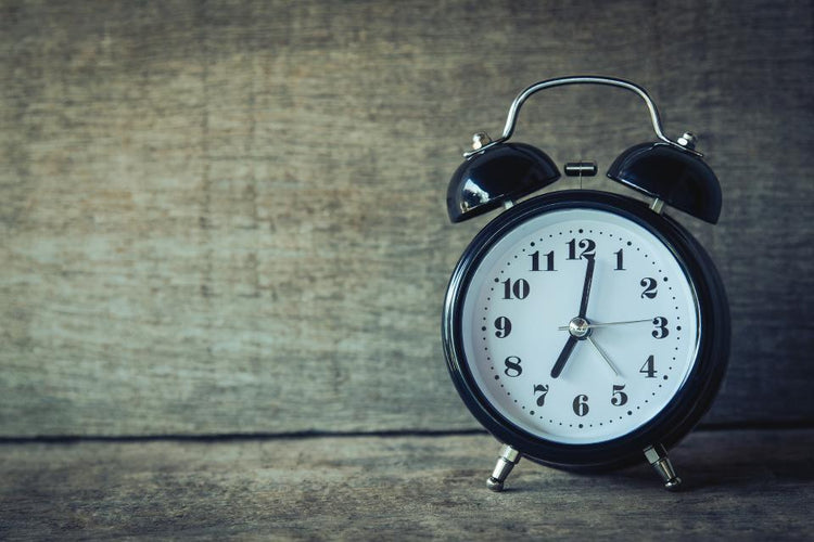 Vintage alarm clock in front of a wood panel wall