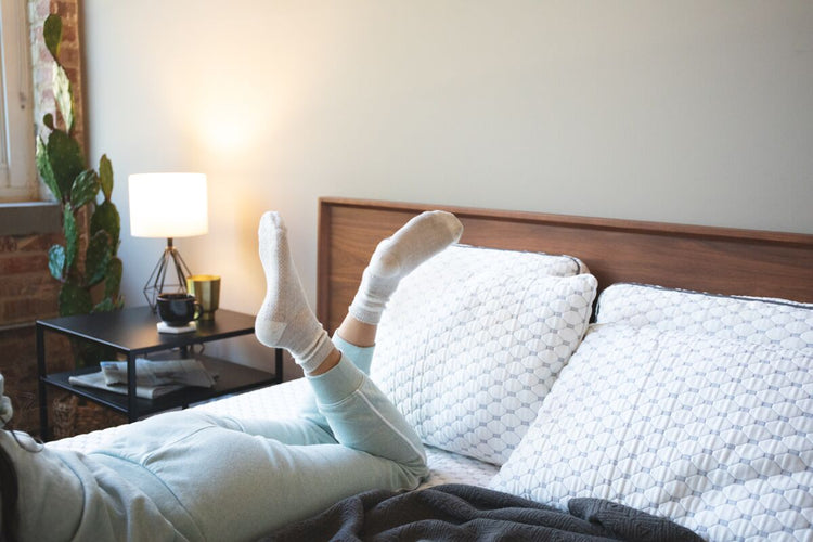 Woman laying on her stomach on her bed.