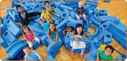 Several school-age children playing with large blocks