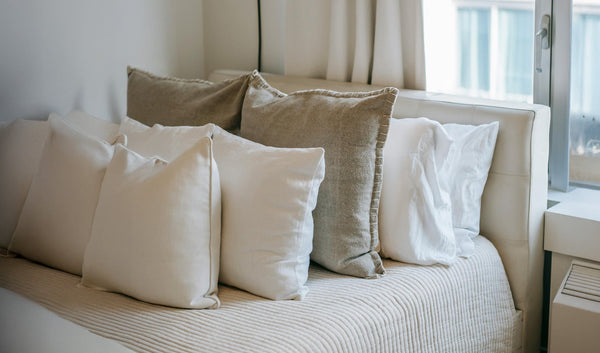 Photo of a bed with a bunch of pillows on it