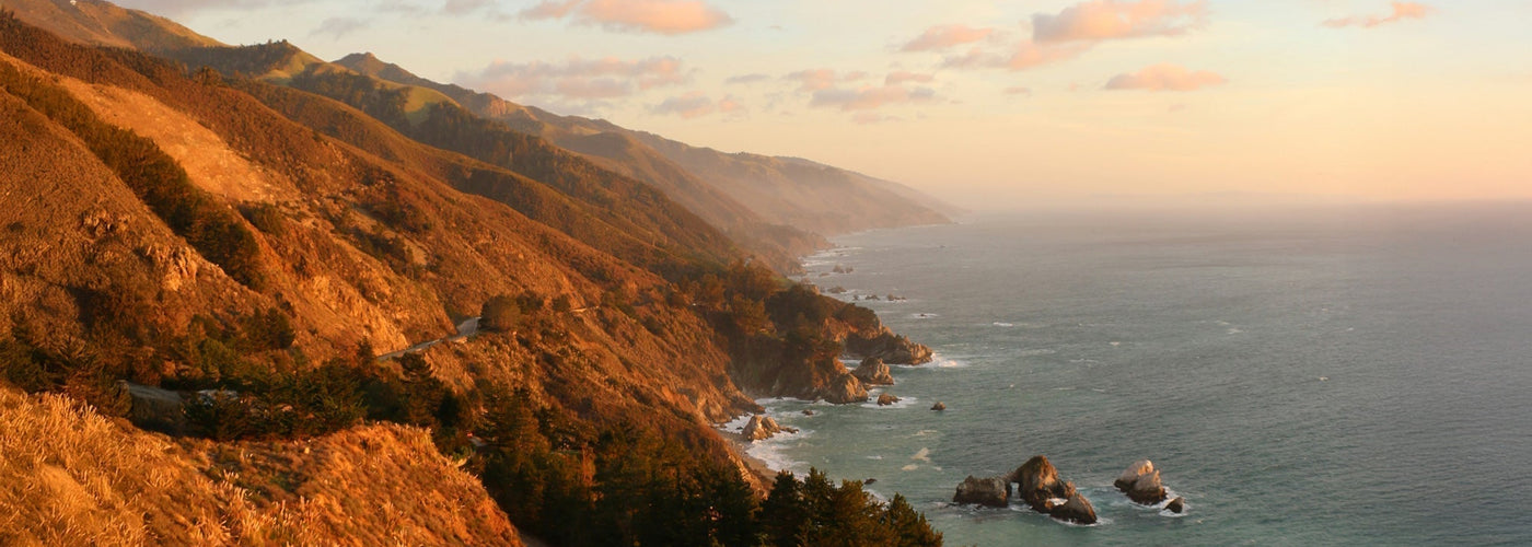 Sunset view of mountain cliffs alongside the Pacific in Big Sur, California.
