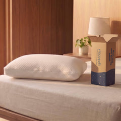 White pillow on a bed next to a Viscosoft packaging box in a bedroom setting.