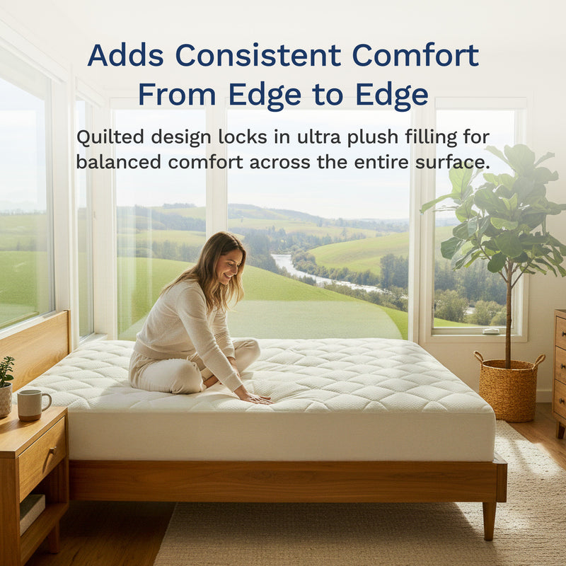 Woman adjusting a mattress in a room with large windows and a view of greenery.