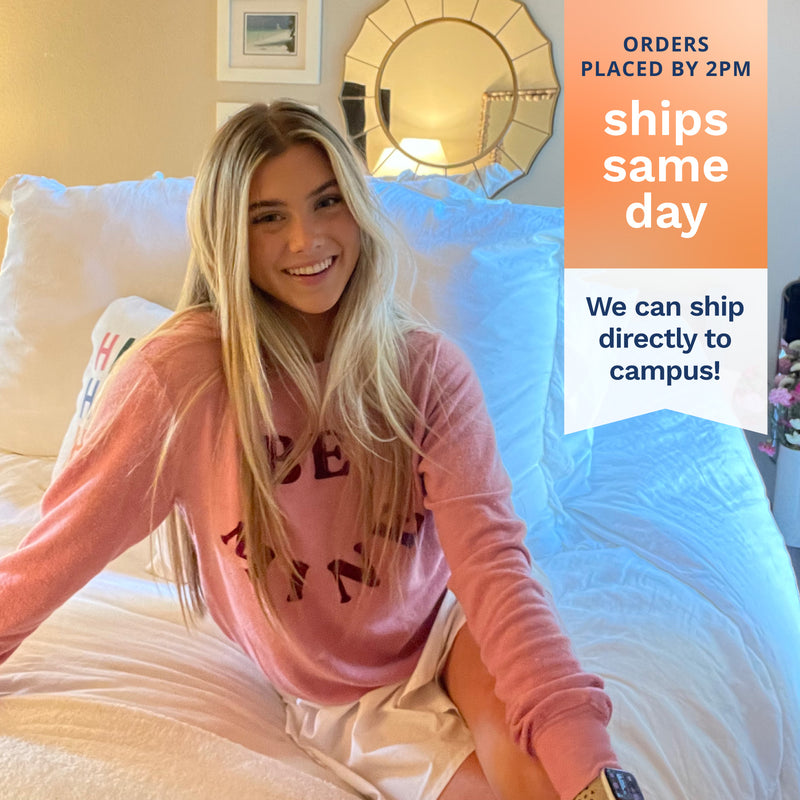 Orders placed by 2pm ships same day. We can ship directly to campus! Photo of a college student sitting on her dorm bed.