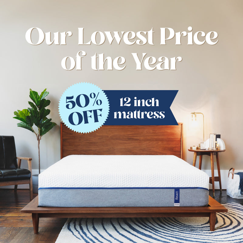 Our Lowest Price of the Year. 50% off 12 inch mattress. A mattress with a cover that is white on the top half and light gray on the bottom half with a blue zipper holding the two fabrics together.