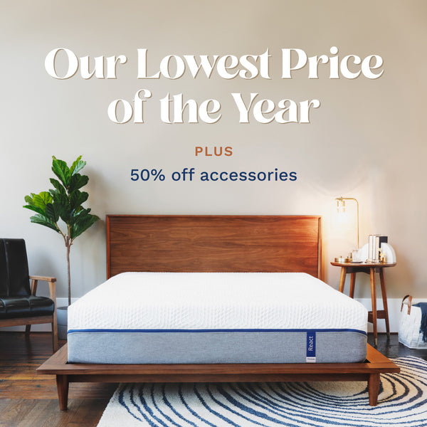 Our Lowest Price of the Year. Plus 50% off accessories. Photo of a mattress with a cover that is white on the top half and light gray on the bottom half with a blue zipper holding the two fabrics together. (No Script)
