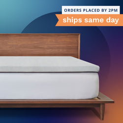 Orders placed by 2pm ships same day. A thick gray mattress topper sitting on top of a bed.