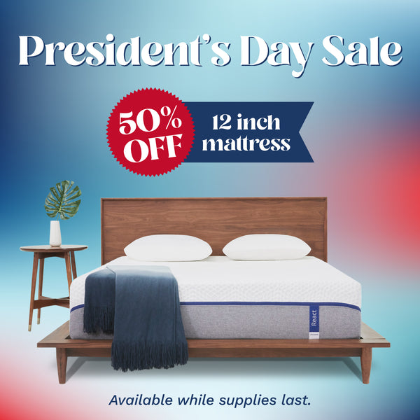 President's Day Sale! 50% off 12 inch mattress. A mattress with a cover that is white on the top half and light gray on the bottom half with a blue zipper holding the two fabrics together. (No Script)