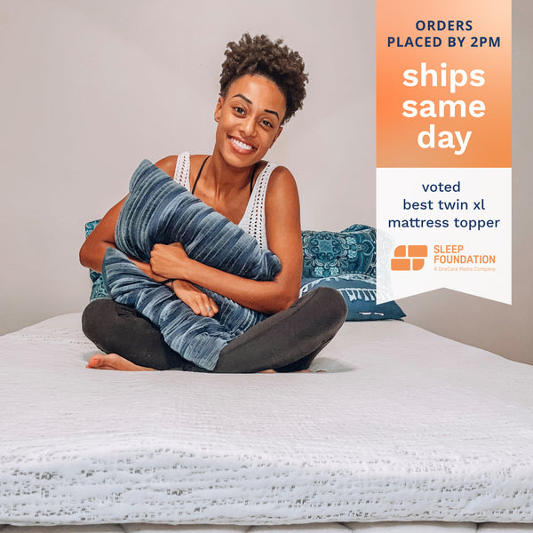 Orders placed by 2pm ships same day. Voted Best Twin XL Mattress Topper by Sleep Foundation. Photo of a college student smiling and sitting on a blue and white mattress topper. (No Script)