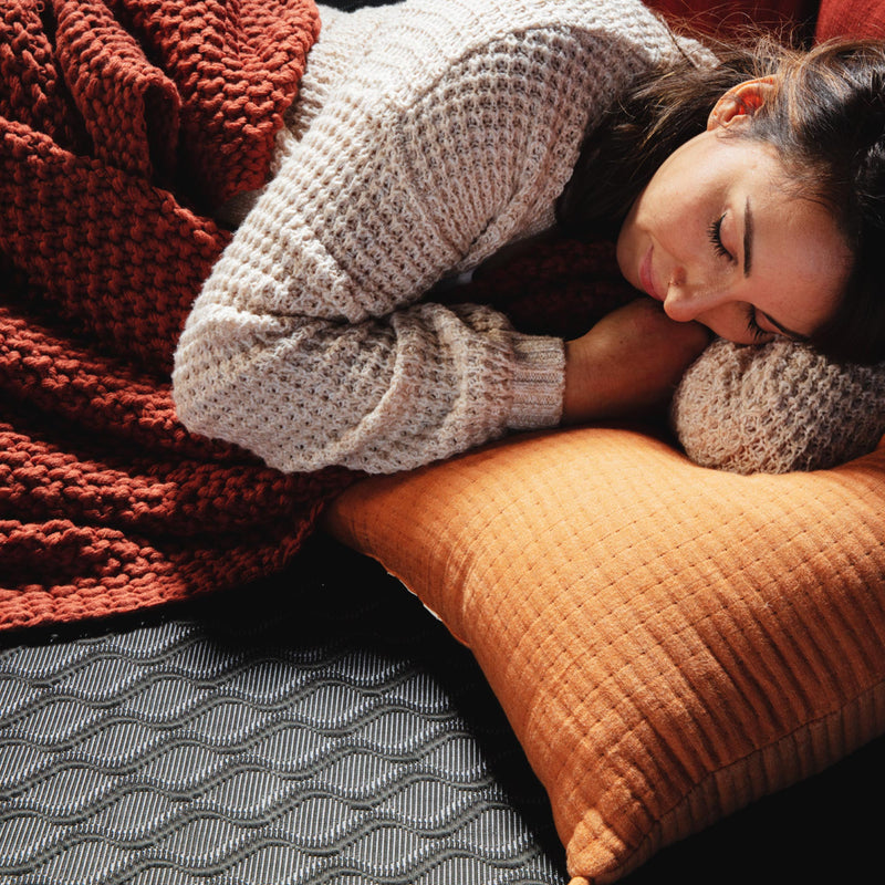 Photo of a woman sleeping on the Black Active Cooling mattress topper.