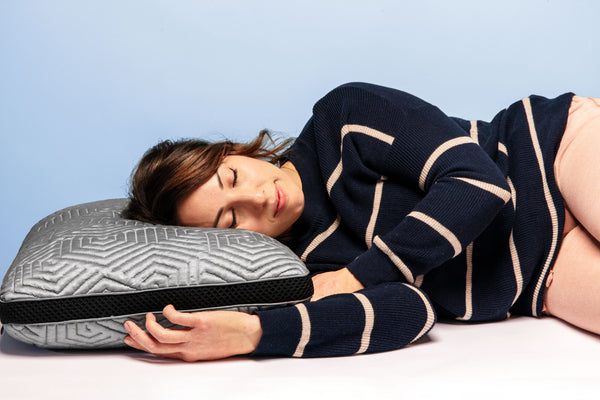Image of a woman resting her head on the Edge Pillow. An adjustable layered pillow designed with a mesh gusset & charcoal gray cooling fabric. (No Script, Alternate View)