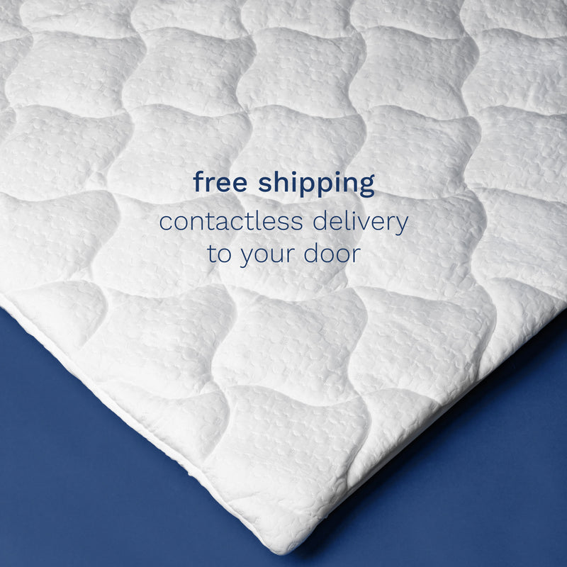 Free shipping. Contactless delivery to your door. Top down photo of the corner of a white pillow top mattress pad. 